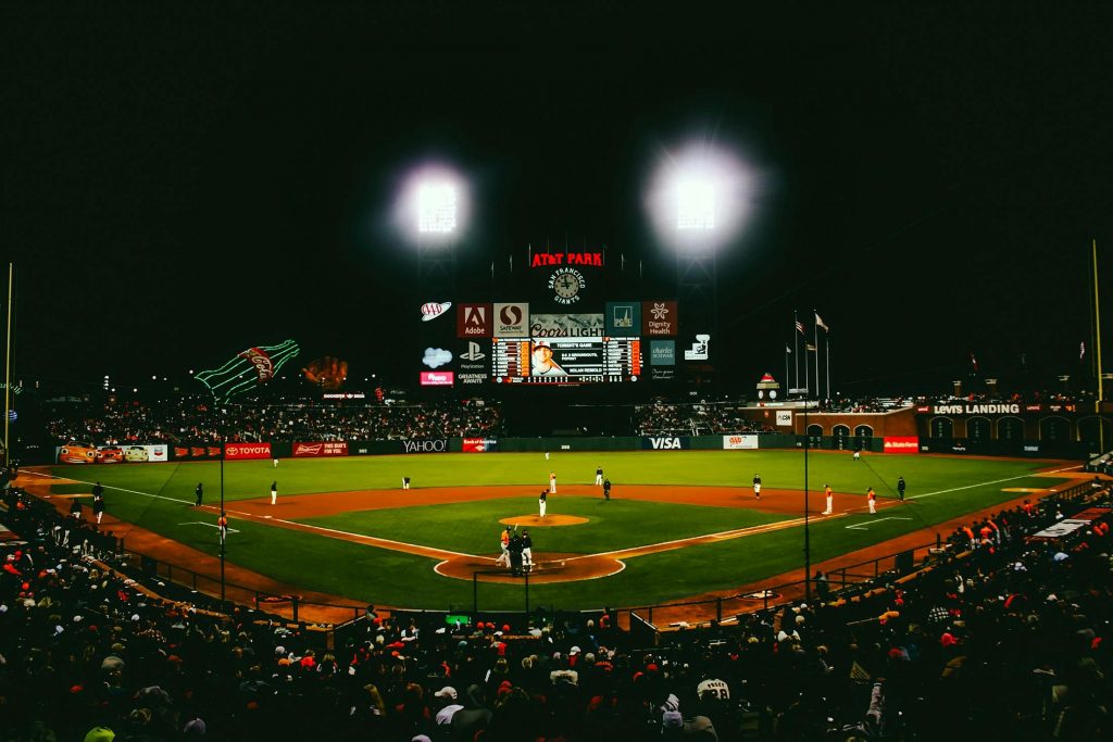 Exciting evening baseball game with fans at AT&T Park stadium under bright lights.