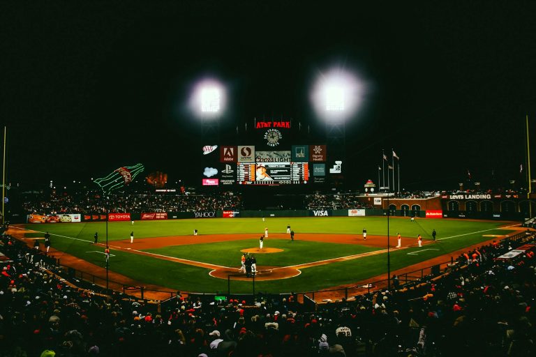 Exciting evening baseball game with fans at AT&T Park stadium under bright lights.